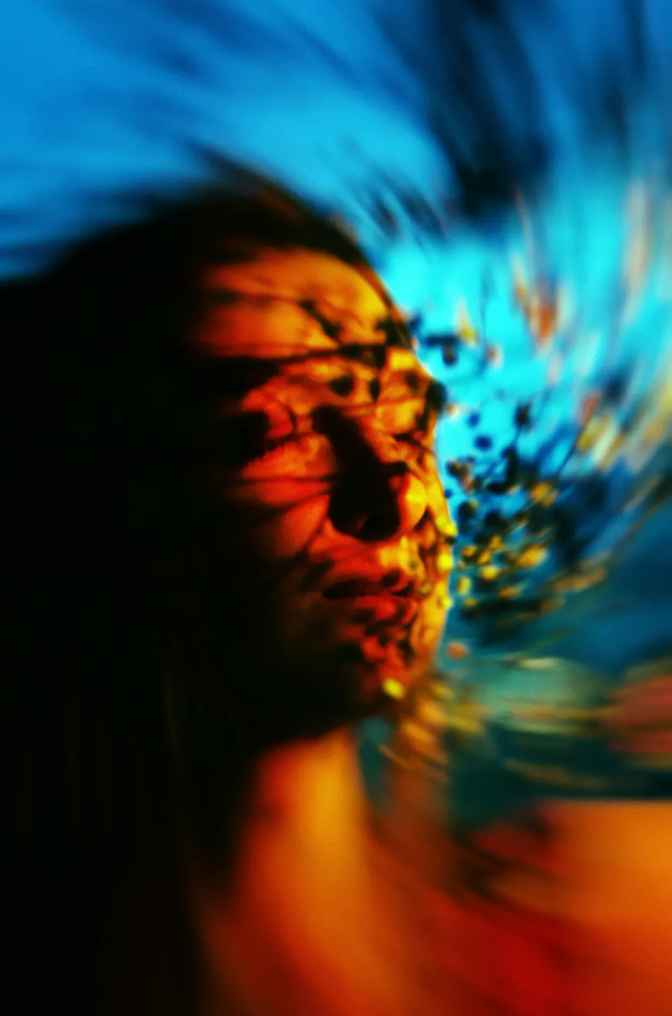 Rosto de mulher em movimento, em tons de azul e laranja